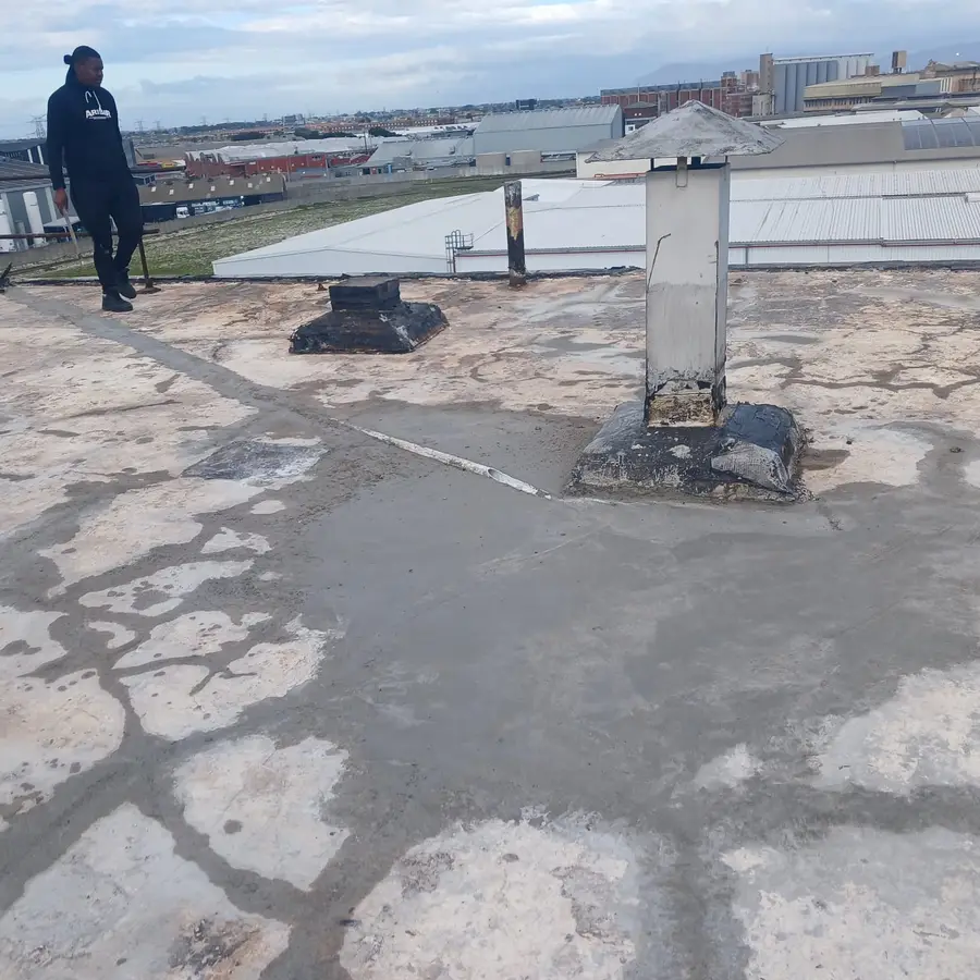Waterproofed vent pipe and flashing detail on an industrial flat roof